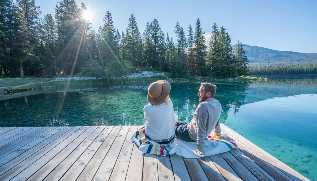Couple profitant du soleil, au printemps et au bord d'un lac canadien